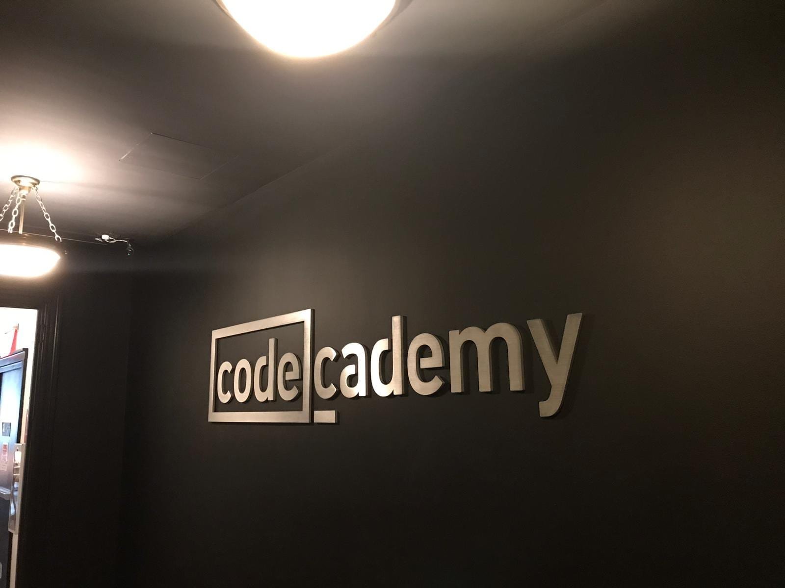 e2fe1bf0-908d-43fc-8e85-a15ee1297f92 - MMK Custom Inc. A sign that says code academy on the wall.