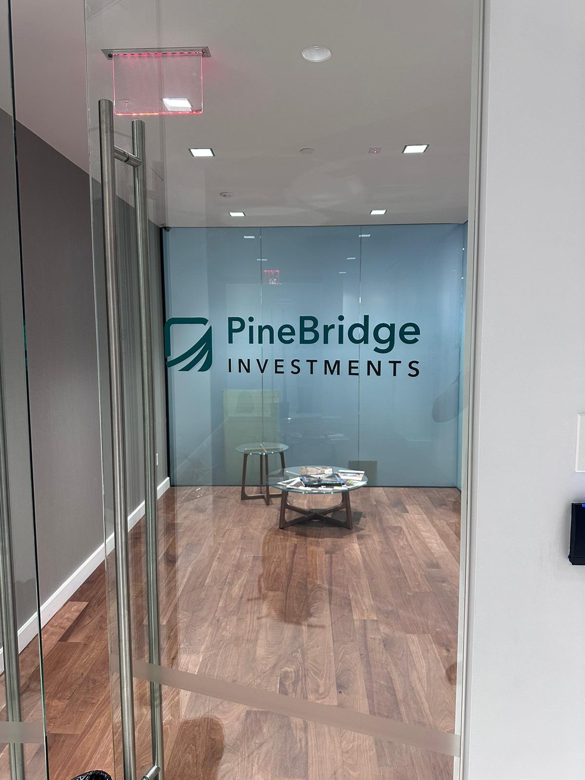 A glass door with the name of pinebridge investments on it.