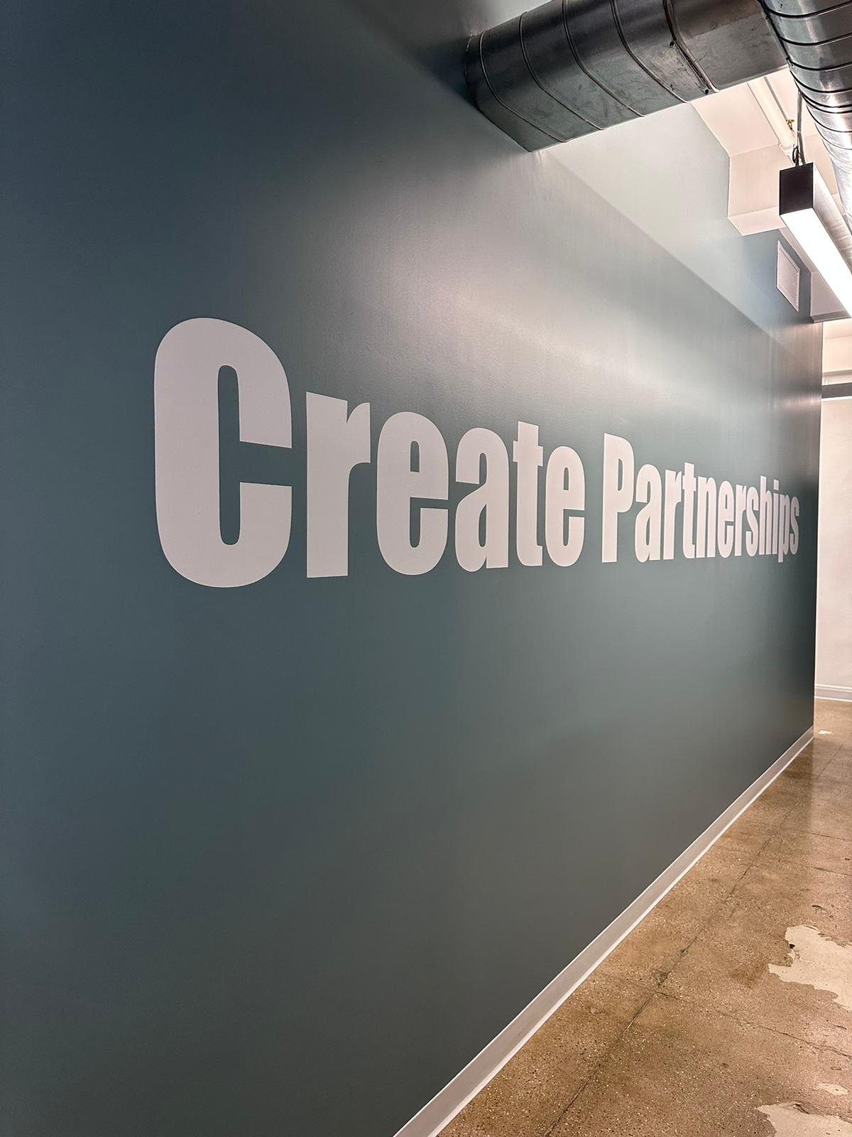 A wall with the words " create partnerships ".