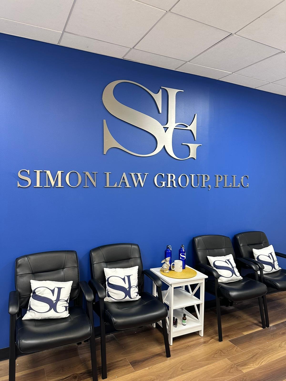 A blue wall with the words " simon law group plla ".