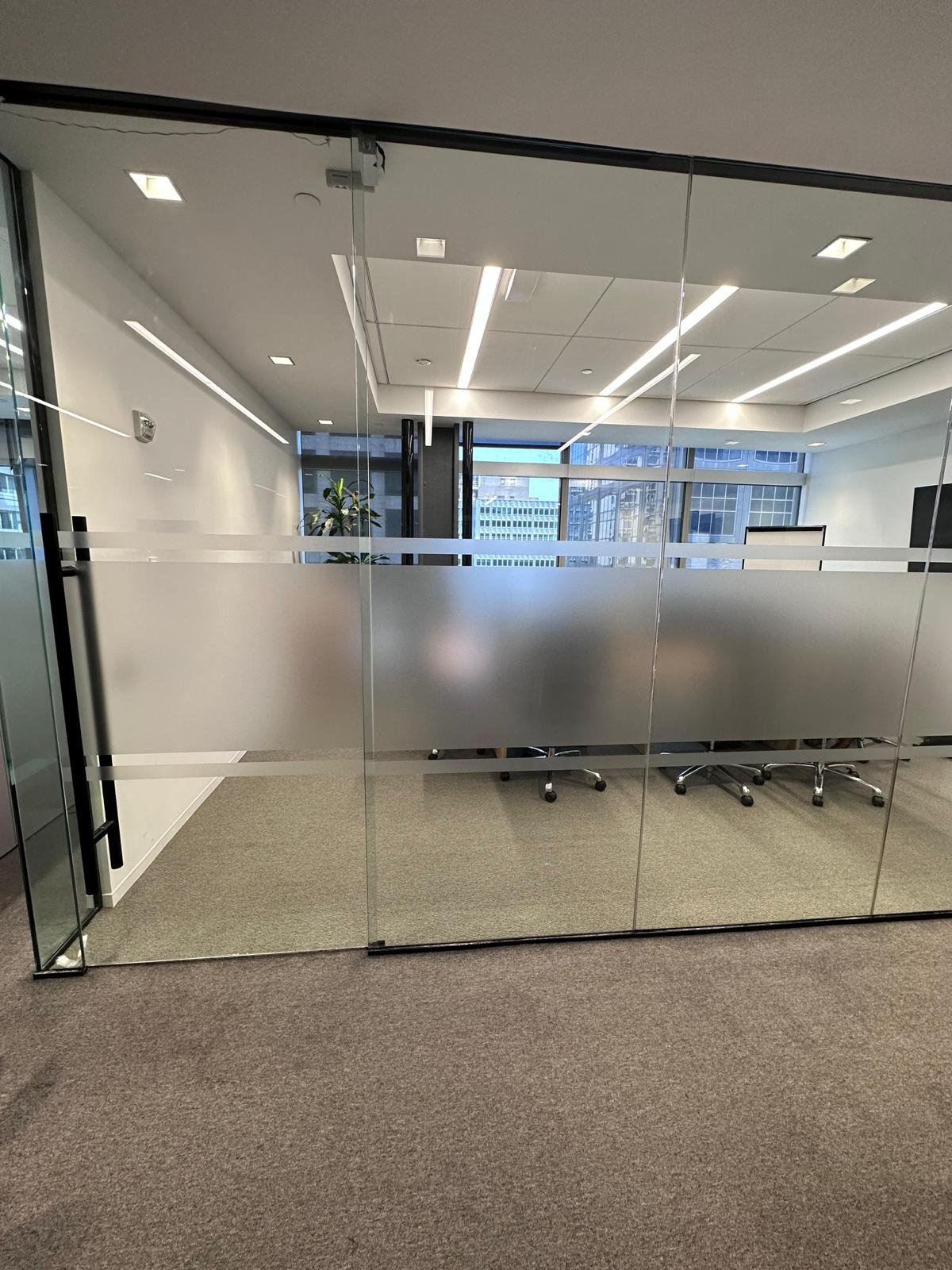 A room with glass walls and a large mirror.