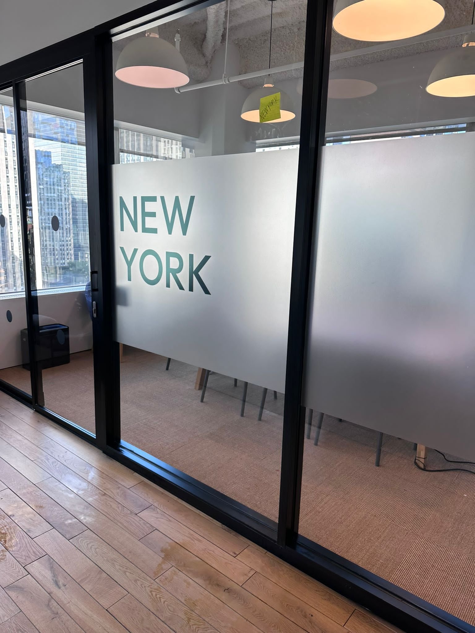 A room with glass doors and windows that say new york.