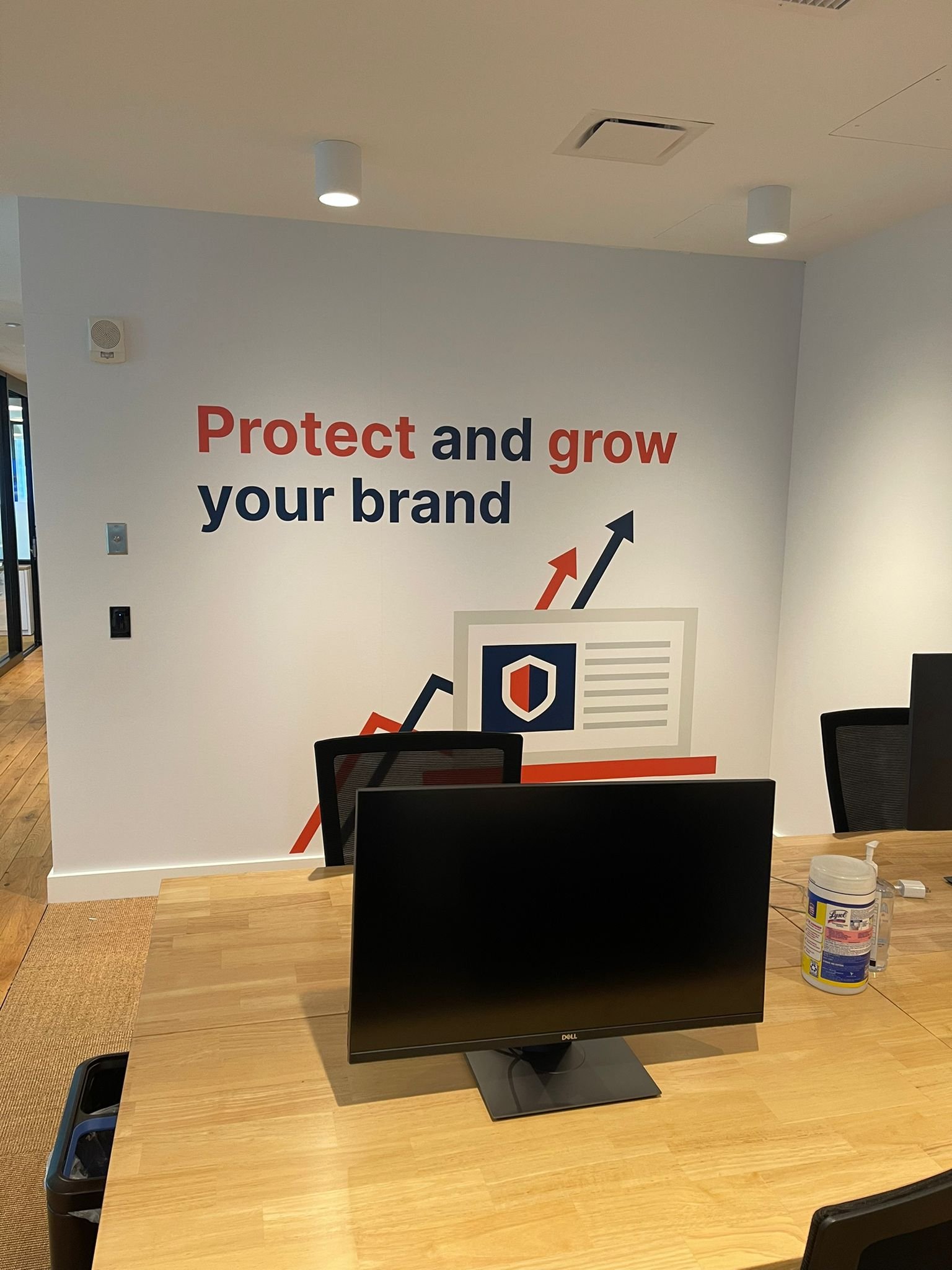 A wall with an advertisement on it and the words protect and grow your brand.