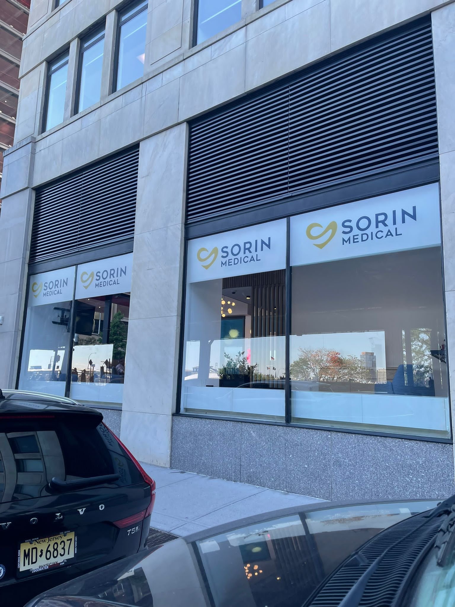 A car parked in front of a building with windows.